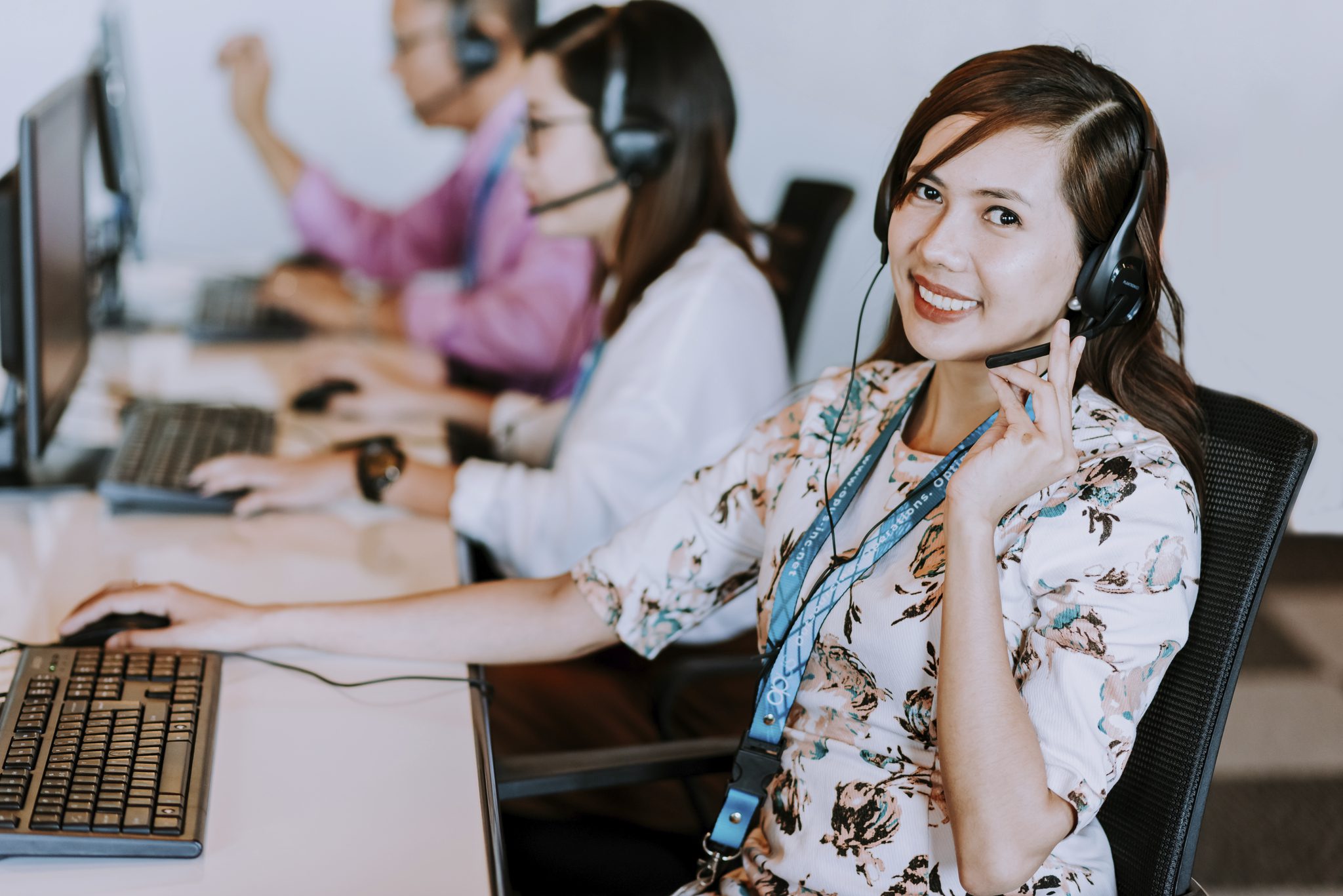 Smiling Female call center agent holding her headset with a headset