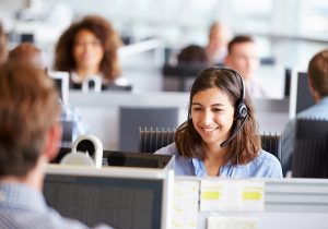 A female agent smiling over a telesales phone call