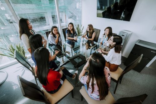 9 Female HR Outsourcing Staff having a Square Glass Table Meeting