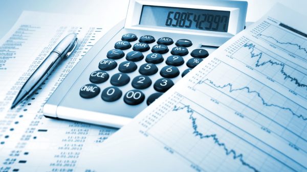 A calculator, pen and financial assets sheet for Finance Outsourcing professionals