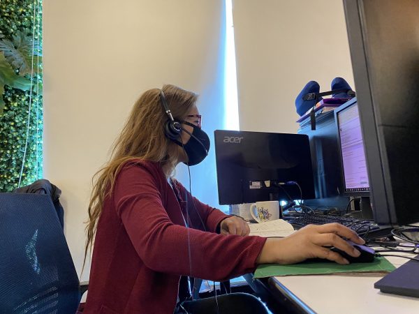 Female Employee in a Face Mask working out her eCommerce Tasks in an Outsourcing Company