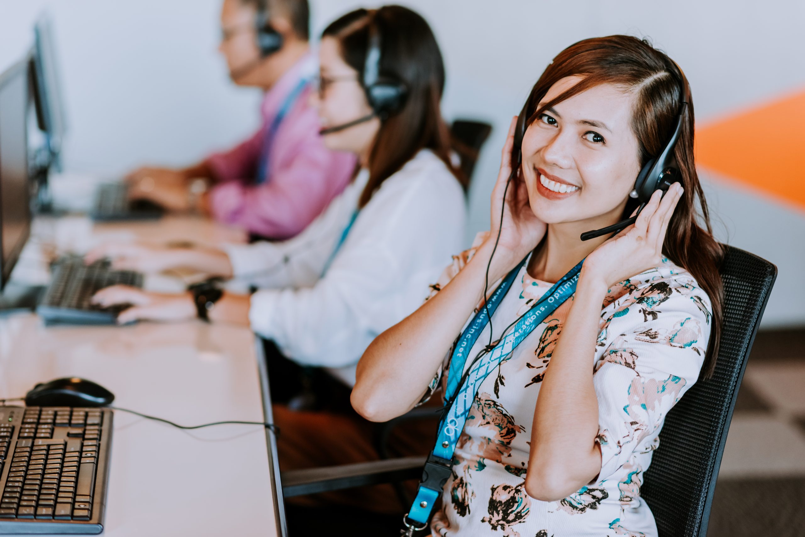female outsourcing employee in a headset smiling