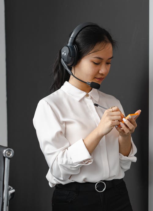 female remote employee in headset taking notes