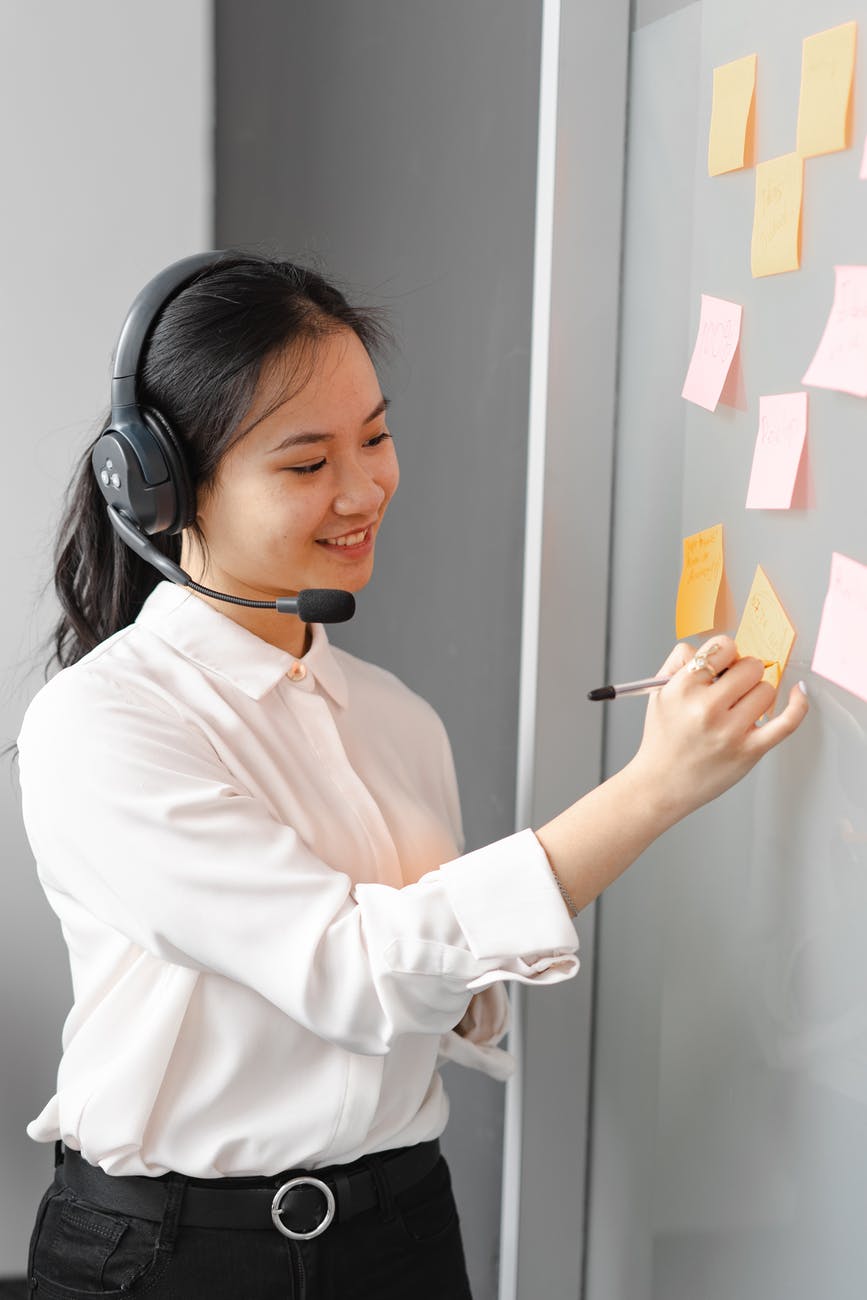 female virtual assistant with headset using sticky notes